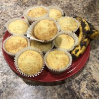 Perfect Banana Muffins on a red plate with whole ripe bananas