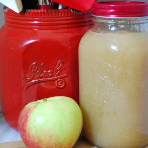 Apple Sauce in a mason jar, whole apple and red mason jar with cooking utensils
