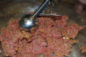 Using ice cream scoop to form meatballs and place on baking dish