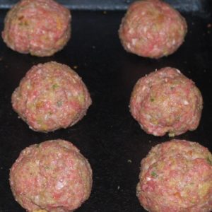 Raw meatballs on a baking sheet