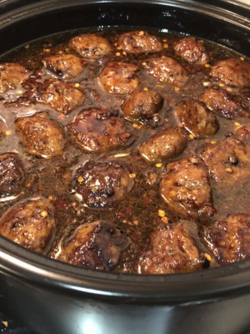20 minute honey garlic meatballs simmering on the stove in a saucepan