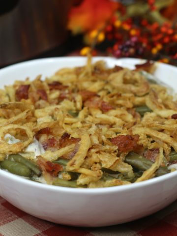 Green Bean Casserole with cooked back and french onions in a white bowl