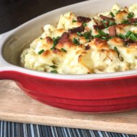 Baked Cauliflower casserole with bacon and cheese in a red dish