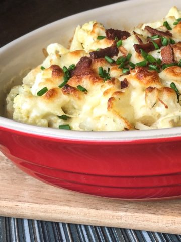 Baked Cauliflower casserole with bacon and cheese in a red dish