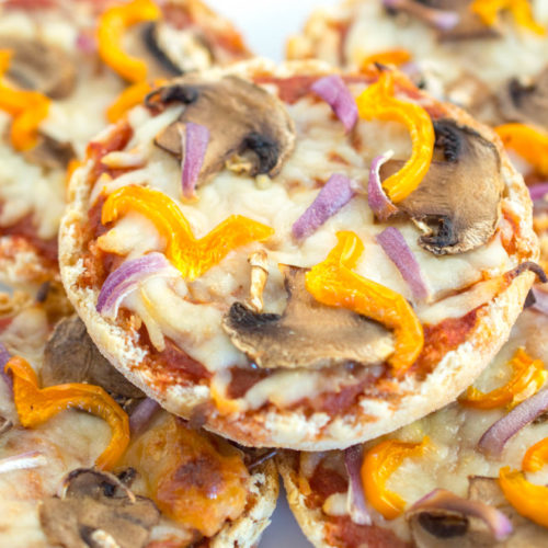 English Muffin with pizza sauce, melted cheese, sliced mushrooms and yellow peppers, close up