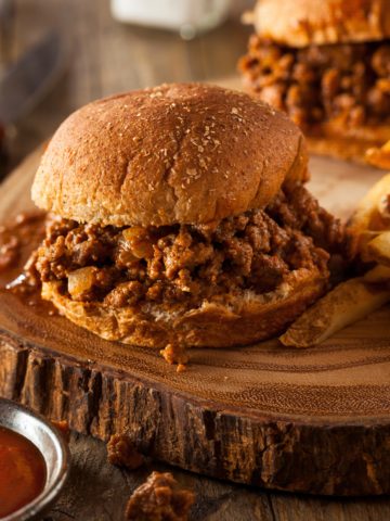 Hamburger bun filled with cooked ground beef in a sweet and smoky BBQ sauce