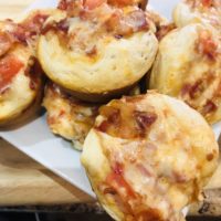 Five flaky biscuits with melted cheese, chopped bacon, salsa, tomatoes and diced red onion