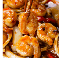 Shrimp, onions, peppers, dried chilies plated with chopsticks standing up