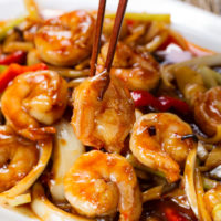 Shrimp, onions, peppers, dried chilies plated with chopsticks standing up