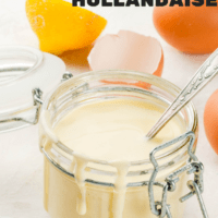 Hollandaise sauce in glass jar, with ingredients for cooking - eggs, butter, lemons. On a white concrete stone table.