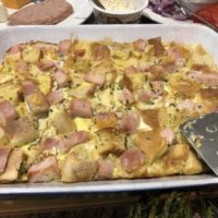 Eggs Benedict Casserole is a 9X13 baking dish with a metal spatula