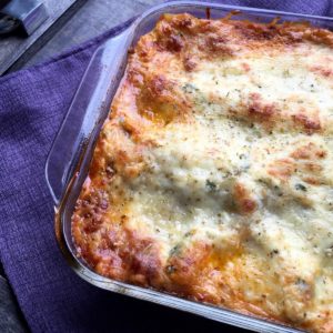 Baked lasagna with meat sauce and 5 cheese in a glass baking dish. Shown whole, not cut.