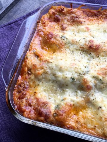 Baked lasagna with meat sauce and 5 cheese in a glass baking dish. Shown whole, not cut.