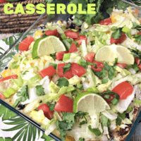 Glass Casserole dish topped with chopped lettuce, tomato, green onions and cilantro. Filling is ground turkey, black beans and corn.