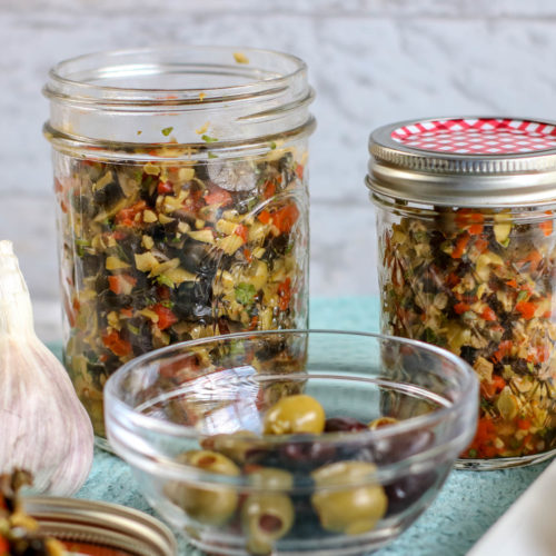 Chopped black, kalamata and green olives in a garlic parsley dressing, stored in small glass mason jars.
