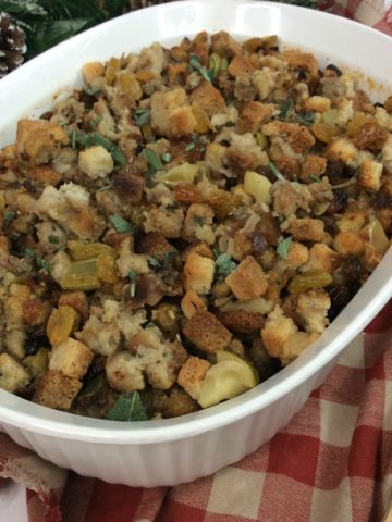 Baked Apple Sausage Stuffing in a white casserole on a red and white checked table cloth