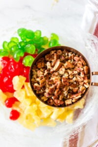 Close up of chopped candied red and green cherries, candied pineapple and chopped pecans for making Fruitcake cookies