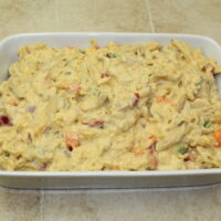 Pasta, Chicken, peppers and cheese in a white baking dish