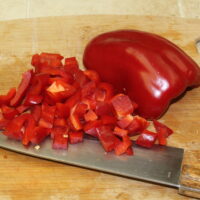 diced red pepper on a wooden cutting board