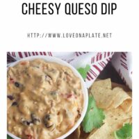 Queso Beef Cheese dip in a white bowl on a board with crisp tortilla chips and cilantro sprigs.
