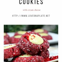 Red Velvet Thumbprint cookies rolled in sanding sugar and filled with cheesecake on a white cookie platter.