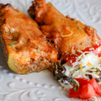 Ground Beef and Enchilada Sauce stuffed Zucchini with melted cheese