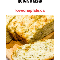 Savoury quick bread with cheddar and garlic sliced on a wooden board