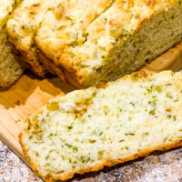 Garlic Cheese Quick bread on a wooden cutting board sliced.